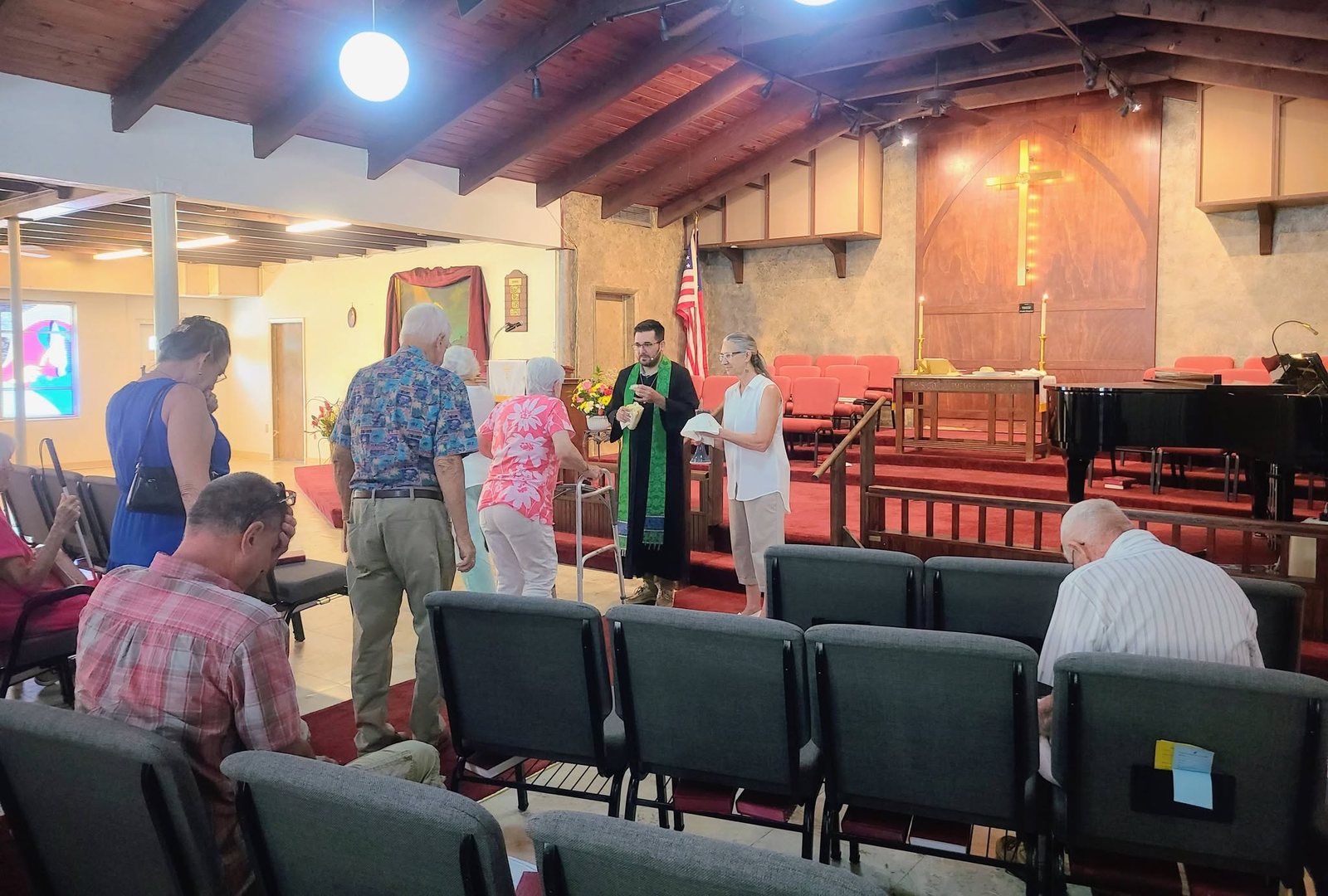 Rev. Rushing Kimball serving Communion as members of the congregation come forward in the sanctuary